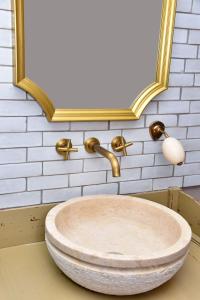 - un lavabo dans une salle de bains avec un cadre en or dans l'établissement Chez Montgaud, à Verdun-sur-Meuse