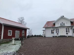 een wit huis en een rood-wit huis bij Nyrenoverad stuga nära naturen in Linköping