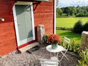 una mesa y sillas frente a un edificio con puerta en Nyrenoverad stuga nära naturen, en Linköping