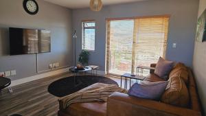 salon z kanapą i telewizorem w obiekcie SS Luxury Apartments w Kapsztadzie