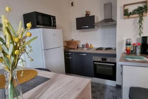cocina con nevera blanca y mesa en Superbe appartement avec parking en Saint-Junien