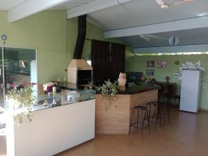 a restaurant with a counter and stools in a room at Pousada Adventures - Suites Luxo Hidromassagem - Piscina - Capitolio MG in Capitólio