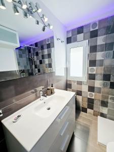 een badkamer met een witte wastafel en een spiegel bij P&L HOUSE Las Olas in Playa del Inglés
