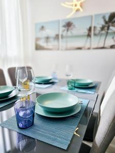 een tafel met borden en een glas wijn bij P&L HOUSE Las Olas in Playa del Inglés