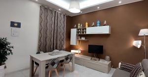 a living room with a table and a television at La Maison SR in Campobasso
