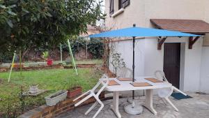 tavolo e sedie con ombrellone blu di Maison saba a Sevran