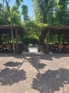 einen Pavillon mit Bänken und Bäumen in einem Park in der Unterkunft Bar Restorant Geshtenja 