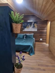 ein Schlafzimmer mit einem grünen Bett und einigen Pflanzen in der Unterkunft Bar Restorant Geshtenja 