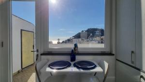 une table avec deux plaques dans une fenêtre dans l'établissement Romy Blu, à Capri
