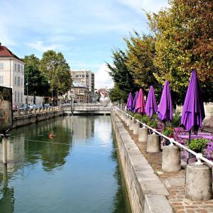 a river with purple umbrellas and a bridge at Le Patio’nnement, Troyes, Centre in Troyes