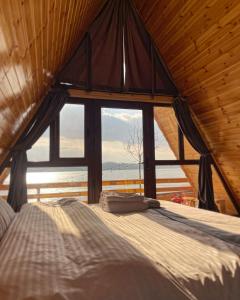 een bed in een kamer met een groot raam bij Potcoava Dunarii in Suhaia
