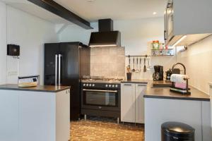 uma cozinha com armários brancos e electrodomésticos pretos em Durbuy Nature em Durbuy