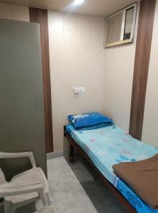 een kleine kamer met een bed en een stoel bij snooze 3 in Panchkula