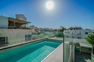 a swimming pool on the roof of a building at Shenkin Dream - 4 BR in Tel Aviv