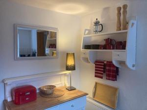 a room with a table with a lamp and a mirror at Ferienwohnung Piesch in Glücksburg +9 photos