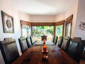 a dining room with a long wooden table and chairs at Villa Alta Vista in Zahara de los Atunes