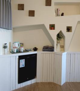 a kitchen with a counter with a black appliance at Flower House B&B in Jiufen