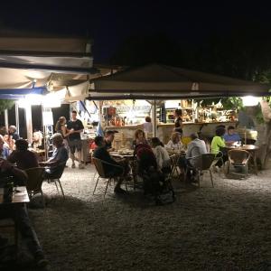 eine Gruppe von Menschen, die nachts an Tischen sitzen in der Unterkunft Maison de pêcheur superbe vue mer, grand jardin in Cadaqués