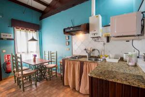 a kitchen with a counter and a table with chairs at Apartamentos El Cueto in Oviñana
