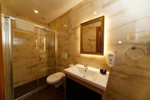 La salle de bains est pourvue d'un lavabo, d'une douche et de toilettes. dans l'établissement Kral Suit Apartment & Hotel, à Istanbul