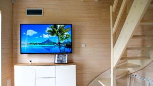 sala de estar con TV de pantalla plana en la pared en Sun Club - Modern Houses Mielno - Mielenko en Mielno