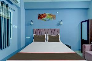a bedroom with a large bed with a blue wall at Collection O Hotel Dream Villa in Patna