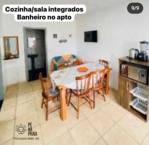 eine Küche mit einem Esstisch und Stühlen in der Unterkunft Pousada Pé na Praia in Imbé
