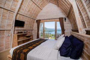 um quarto com uma cama num quarto com uma janela em Samuh Camp Kintamani em Kintamani