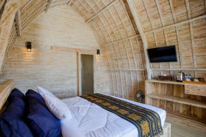 a bedroom with a bed and a tv in a room at Samuh Camp Kintamani in Kintamani