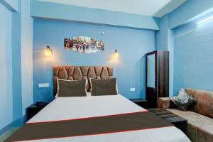 a bedroom with a large bed and a couch at Collection O Hotel Dream Villa in Patna