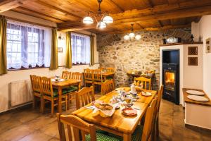 ein Esszimmer mit Holztischen und -stühlen und einem Kamin in der Unterkunft Pension Krumau in Český Krumlov