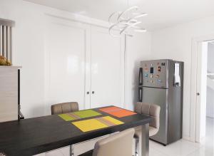 ein Esszimmer mit einem Tisch und einem Kühlschrank in der Unterkunft Casa Mancappello in Montebelluna