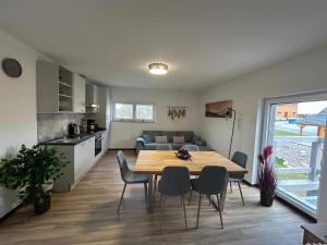 Una cocina y una sala de estar con mesa y sillas. en Haus Herzglück, en Rheinsberg