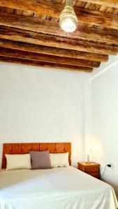 a bedroom with a bed with a wooden ceiling at Maison d'hôtes "Dar Khalifa" in Tozeur