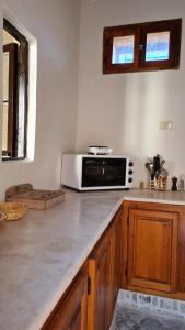 a kitchen with a counter top with a microwave at Maison d'hôtes "Dar Khalifa" in Tozeur