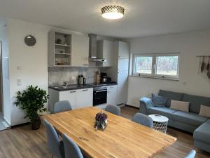 Una cocina y una sala de estar con una mesa y un sofá. en Haus Herzglück, en Rheinsberg 26 fotos más