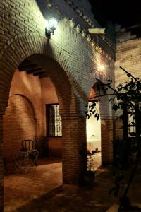 une arche en briques avec une table dans un bâtiment dans l'établissement Maison d'hôtes "Dar Khalifa", à Tozeur
