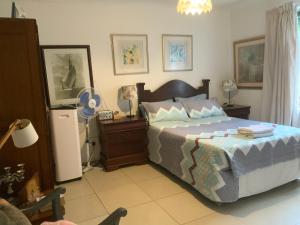 a bedroom with a bed and a refrigerator in it at Coz Guesthouse in Randburg in Johannesburg