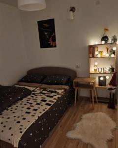 een slaapkamer met een bed en een tafel met een tapijt bij Oaza031 in Užice