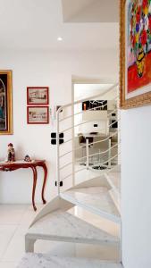 Habitación blanca con escalera y mesa en Casa Mancappello, en Montebelluna
