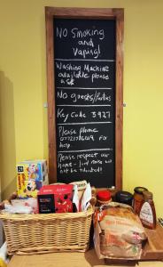 un tableau noir avec un menu et un panier de nourriture dans l'établissement The Annex, à Baie de Cemaes
