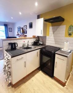 a kitchen with a sink and a stove at The Annex in Cemaes Bay