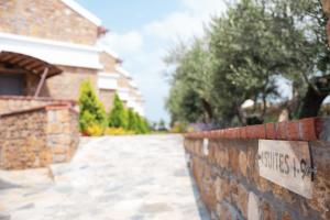 a brick wall with a sign that reads synergy at Akrolithos Luxury Suites & Spa in Flogita