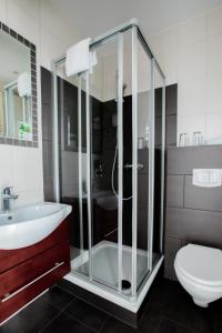 a bathroom with a glass shower and a toilet at Hotel Das Kronprinz in Troisdorf