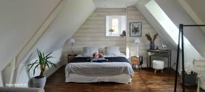 a little girl sitting on a bed in a attic at Au Nid de Caroline gîte 4 étoiles in Arette