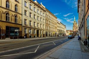 an empty city street with buildings and cars on the road at Stare Miasto Krupnicza in Wrocław