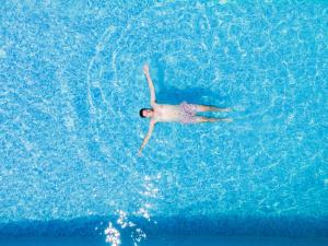 a person is swimming in a swimming pool at Akrolithos Luxury Suites & Spa in Flogita