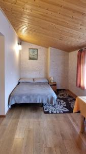 1 dormitorio con cama y techo de madera en Mountain House, en Ustrzyki Dolne
