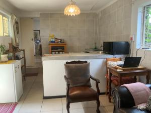 a kitchen with a chair and a table with a laptop at Coz Guesthouse in Randburg in Johannesburg