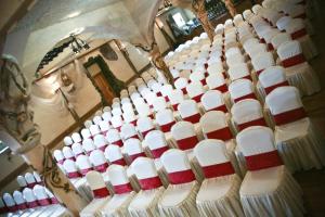 a group of white chairs with red and white napkins at Impresja Krasiczyn in Przemyśl